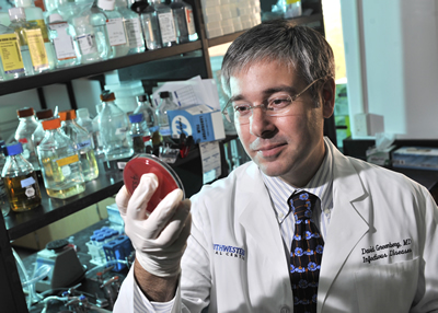 Dr. David Greenberg, assistant professor of internal medicine and microbiology, checks a sample for growth of Acinetobacter.